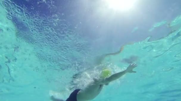 Hombre de cámara lenta nadando bajo el agua en la piscina — Vídeo de stock