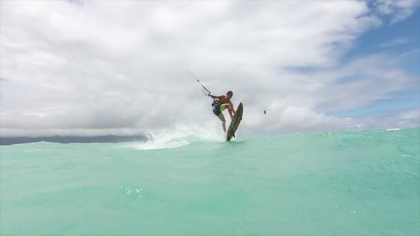Mladý samec kite surfingu v oceánu má extrémní trik — Stock video