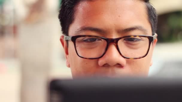 Молодой человек читает планшетного компьютера сенсорный экран в кафе — стоковое видео