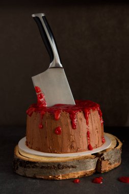 Pastaya bıçak saplanmış kanlı canavar pastası. Çikolatalı Cadılar Bayramı keki.