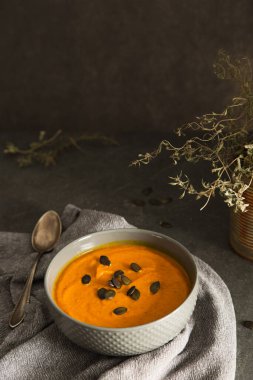 Kabak çorbası, kabak çekirdeği ile servis edilir. Vejetaryen çorbası. Koyu arkaplan.