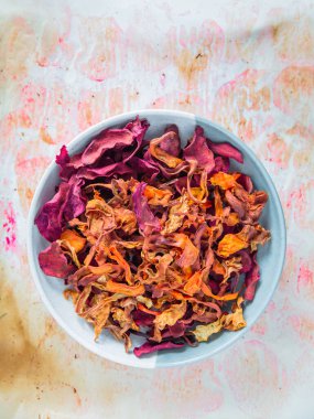 Bir kase sağlıklı sebze cipsi ve parlak bir arka plan. Pancar, havuç, maydanoz ve kereviz sağlıklı bir atıştırmalıktır. Yukarıdan bak. tekst üzerinde yer.