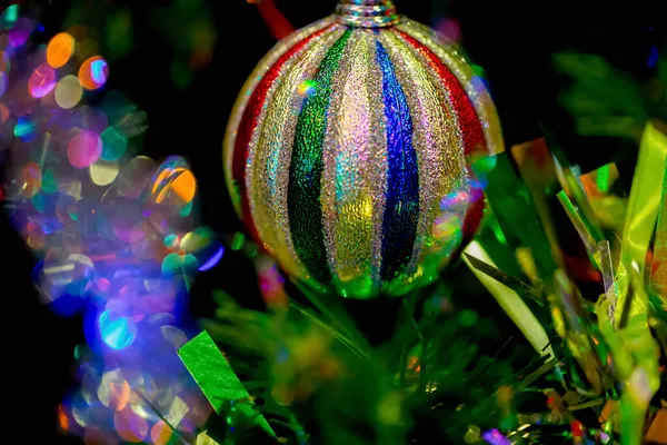 Close-up de bola de Natal colorido em uma árvore festiva. Bokeh colorido. Fundo desfocado. Profundidade de campo rasa. Foco suave — Fotografia de Stock