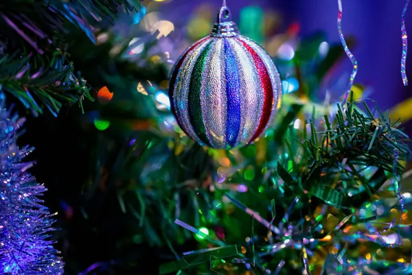 Weihnachtskugel auf einem festlichen Baum. Bokeh. Dunkler verschwommener Hintergrund. Geringe Schärfentiefe. Makro. — Stockfoto