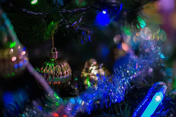 Bolas de ouro e grinalda em um ramo de uma árvore de Natal. Feliz Ano Novo. Profundidade de campo rasa. Imagem tonificada, foco suave — Fotografia de Stock