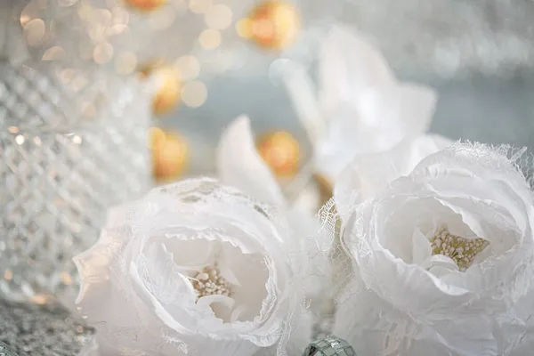 Silk white roses with lace and blurred light background with beautiful bokeh. Christmas decoration to decorate the festive table. — Stock Photo, Image