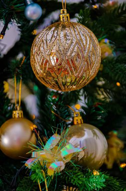 Altın renkli süslemeler Noel ağacını balon gibi süslüyor ve güzel sarı bir çelenk. Koyu arkaplan