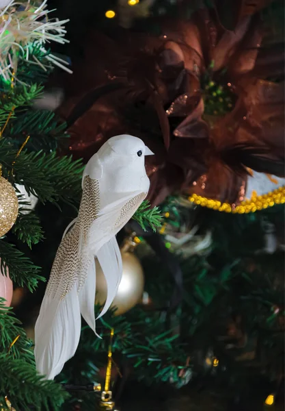 Oiseau blanc et fleur de soie sur le sapin de Noël et un fond sombre flou avec bokeh. Concentration douce. — Photo