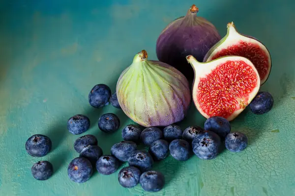 Figs and blueberries on a green old table. Copy space. Top view. — Foto de Stock