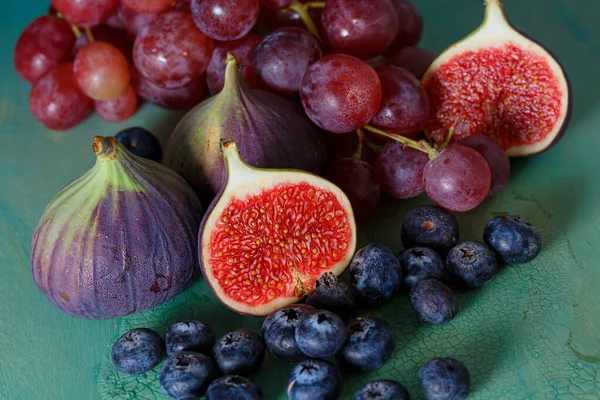 Fruits. Top view of figs, pink grapes and blueberries on a green old table. — Foto de Stock