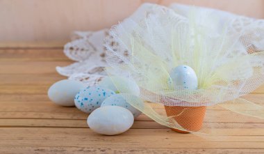 Şeffaf kumaşla benekli tatlı beyaz yumurtalar. Arka plan bulanık. Paskalya için tebrik kartları. Boşluğu kopyala.