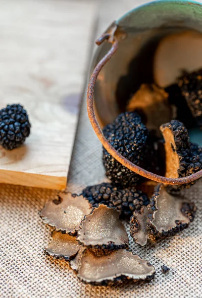 Champiñones en rodajas finas en un pequeño cubo de cobre. Deliciosas trufas crudas. Champiñones negros. Vista superior. Profundidad superficial del campo. —  Fotos de Stock