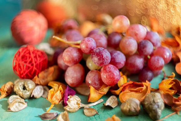 Uvas rosadas y sobre una vieja mesa verde. Frutas. Borroso hermoso fondo con bokeh amarillo. — Foto de Stock
