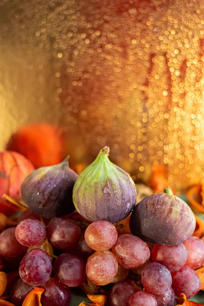 Beautiful glowing bokeh on a blurred background of water drops. Grapes and figs. Autumn composition of fruits. Copy space. — стоковое фото