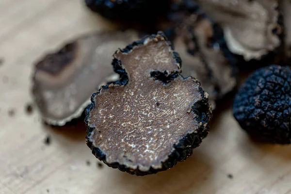 Black truffles of Saint John on a beige burlap.Thinly sliced mushrooms. Raw champignons. Shallow depth of field. Images De Stock Libres De Droits