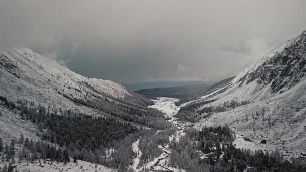 The foot of the glacier of the huge Belukha mountain, the valley of the Aktru River, the Altai mountains. Cloudy weather, storm, wildlife, winter forest, frozen mountain river in the valley of the — Stock Video