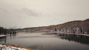Altai, Sibirya, Rusya. Kışın, arkasında beyaz karla kaplı dağlar olan ıssız, boş bir dağ gölü. Karla kaplı ormanlar, bir otoyol, suda yansımalar. Özgürlük, yalnızlık