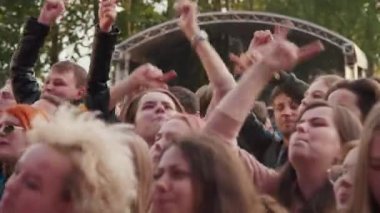 Gençlerden oluşan bir kalabalık, sahne önünde dans eden hayranlar, Stereoleto Yaz Müzik Festivali, St. Petersburg, Sevkabel 2020 'de müzik dinliyorlar. Parti, yaz havası, arkadaşlık, gençlik