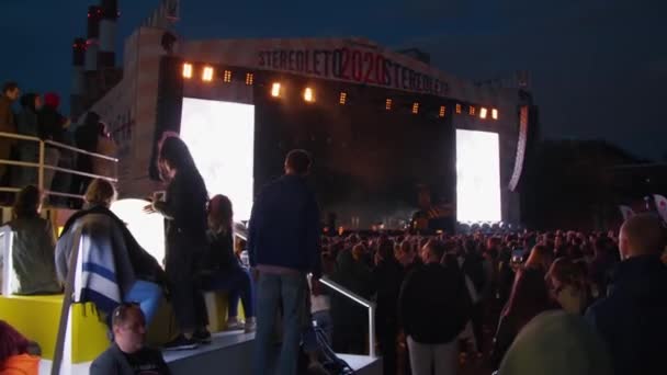 A crowd of young people, fans dancing in front of the stage, enjoying music at night at the Stereoleto Summer Music Festival, St. Petersburg, Sevkabel 2020. Party, summer atmosphere, friendship, youth — Stock Video