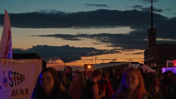 Общая ночная атмосфера на закате на Летнем музыкальном фестивале Stereoleto, Санкт-Петербург, Севкабель-2020. Проходящие люди, посетители, вечеринка, летняя атмосфера, дружба, молодежь — стоковое видео