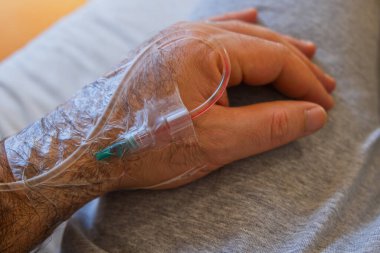 drip cannula inserted into the hand of a hospital patient clipart