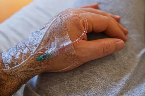 Drip cannula inserted into the hand of a hospital patient Stockafbeelding