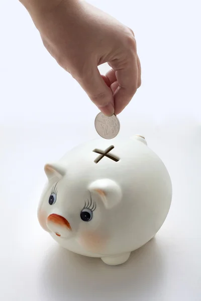 Savings - Piggy bank and hand with coin — Stock Photo, Image