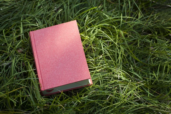 Blank red book on grass — Stock Photo, Image