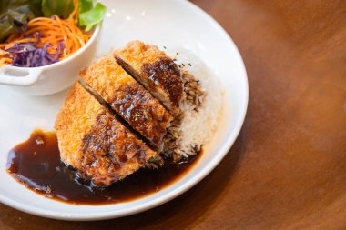 Pirinç aromalı Tonkatsu domuz pirzolası. Japon yemeği. Ekmekli, bol yağda kızartılmış domuz pirzolası ve teriyaki soslu. Popüler ulusal basit yiyecek kavramını kabul et.