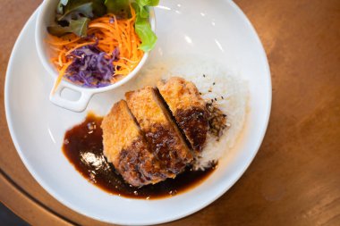 Pirinç aromalı Tonkatsu domuz pirzolası. Japon yemeği. Ekmekli, bol yağda kızartılmış domuz pirzolası ve teriyaki soslu. Popüler ulusal basit yiyecek kavramını kabul et.