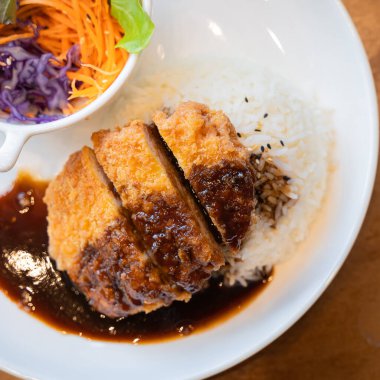 Pirinç aromalı Tonkatsu domuz pirzolası. Japon yemeği. Ekmekli, bol yağda kızartılmış domuz pirzolası ve teriyaki soslu. Popüler ulusal basit yiyecek kavramını kabul et.