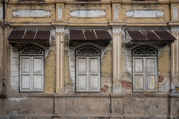 Alçak levrek kaplamasında ve pencere kemerlerinin üstündeki ön cephede yer alan antik binalar, ahşap şablon saçakları. Mimari dış tasarım süslemeli eski tarihi binalar konsepti.
