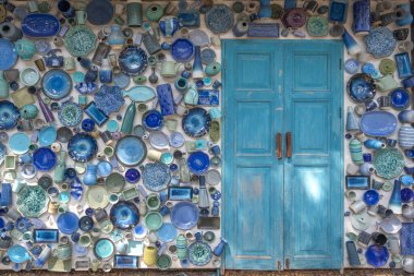 Renkli seramik kaplamalı güzel mavi ahşap kapılar arka planda mavi kaplar süsledi. Vintage dış bina kavramı.