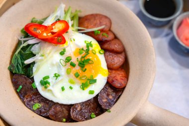 Çin sosisi kızartılmış pilav ve kızarmış yumurta lezzetli Çin yemeği. Beyaz kil kapta servis ediliyor, seçici bir odak noktası. Geleneksel yemek pişirmek için sağlıklı beslenme kavramı.