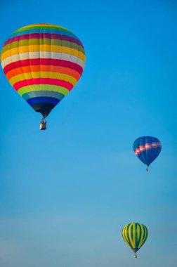 Açık mavi arka planda uçan güzel renkli sıcak hava balonu. Mutlu tatil seyahatleri, aşkla.
