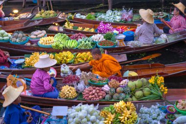 Ratchaburi, Tayland - 15 Kasım 2020: Kadınlar Damnoen Saduak Yüzen Pazarı 'ndaki keşişe para yardımı yaptı Tayland kanallarında teknelerin popüler turizm merkezleri.