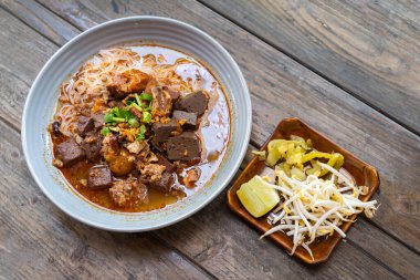 Pirinç vermicelli şehriye ya da Taylandlı adı Khanom Jeen Nam Ngeow Tayland 'ın kuzeyinde, Chiang Mai' nin en sevdiği lezzetli yiyecektir. Geleneksel yemekleri ahşap bir masada düşünün..