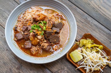 Pirinç vermicelli şehriye ya da Taylandlı adı Khanom Jeen Nam Ngeow Tayland 'ın kuzeyinde, Chiang Mai' nin en sevdiği lezzetli yiyecektir. Geleneksel yemekleri ahşap bir masada düşünün..