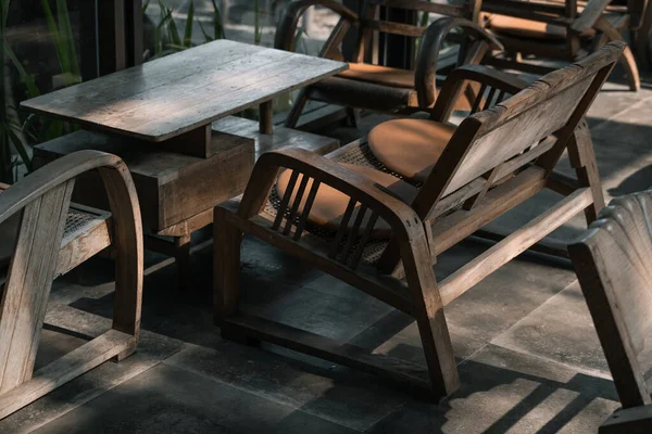 나무로 의자가 휘어진 팔걸이와 내부에 오렌지 패드가 테이블 커피숍 빈티지 — 스톡 사진