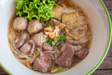 Tayland 'da sığır eti, ciğer ve köfte ile etli erişte çok lezzetlidir. Eski ahşap masada Çin usulü. Asya 'nın en sevdiği Tayland sokak yemekleri Çin tarzı..