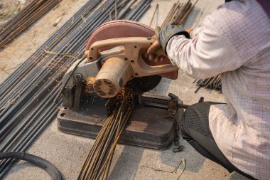 İnşaat işçileri inşaat alanında çeliği kesmek için çalışıyorlar. Mimarlık inşaatında çalışan kavramsal işçiler.