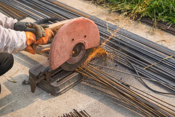 İnşaat işçileri inşaat alanında çeliği kesmek için çalışıyorlar. Mimarlık inşaatında çalışan kavramsal işçiler.