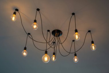 Retro Tungsten Edison tavan lambaları gri çimento arka plan iç ofis binası ya da ev ve yaşam üzerine dekore edilmiş. Göz kamaştırıcı ışık kavramını kabul edin mobilya vintage ev çağdaş.