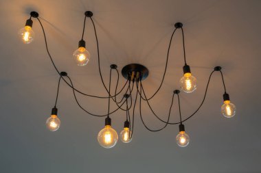 Retro Tungsten Edison tavan lambaları gri çimento arka plan iç ofis binası ya da ev ve yaşam üzerine dekore edilmiş. Göz kamaştırıcı ışık kavramını kabul edin mobilya vintage ev çağdaş.