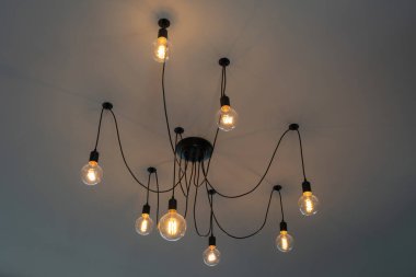Retro Tungsten Edison tavan lambaları gri çimento arka plan iç ofis binası ya da ev ve yaşam üzerine dekore edilmiş. Göz kamaştırıcı ışık kavramını kabul edin mobilya vintage ev çağdaş.