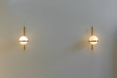 Modern yuvarlak lamba ampulleri top şeklinde altın metalik bir süs ve duvar dekorasyonunda dikey olarak altın bir çubuk bulunur ve kopya metni için yeri vardır. Çağdaş yapıyı kabul et.