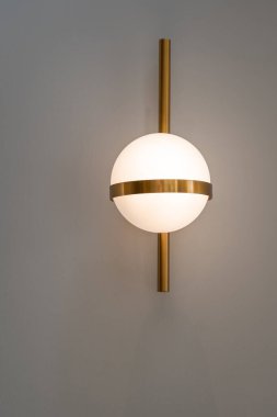 Modern yuvarlak lamba ampulleri top şeklinde altın metalik bir süs ve duvar dekorasyonunda dikey olarak altın bir çubuk bulunur ve kopya metni için yeri vardır. Çağdaş yapıyı kabul et.