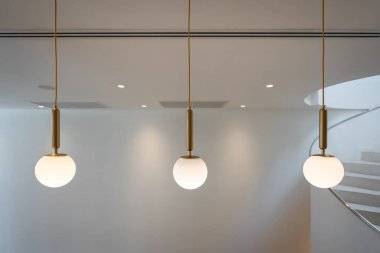 Üç lambadan oluşan güzel modern grup ev için ampul küre şeklindeki dekorasyonu ve metin için fotokopi alanı olan duvar zemininde yaşaması. İç yapı kavramı çağdaş.