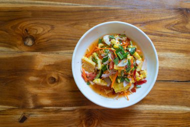 Mısır ve Papaya salatası ya da Tayland 'da tuzlu yumurtalı Som Tum Kao Pod ya da Fruit Som Tum, Tayland' ın kuzeydoğusunda popüler lezzetli bir yemektir. Tatlı mısır baharatlı Tayland yemeği salatası üst görünüm konsepti.