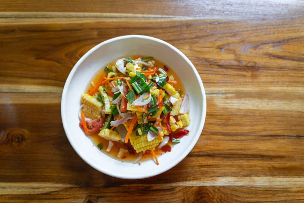 Mısır ve Papaya salatası ya da Tayland 'da tuzlu yumurtalı Som Tum Kao Pod ya da Fruit Som Tum, Tayland' ın kuzeydoğusunda popüler lezzetli bir yemektir. Tatlı mısır baharatlı Tayland yemeği salatası üst görünüm konsepti.